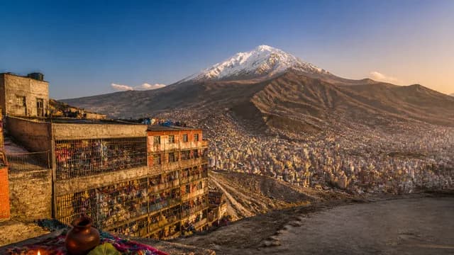 Man wearing oxygen mask overlaid on dense mountainous city nestled between towering peaks and high-altitude landscape