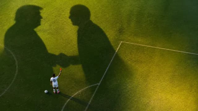 BBC News logo with split-screen showing a football player on the left and a man in a dark suit at a microphone on the…