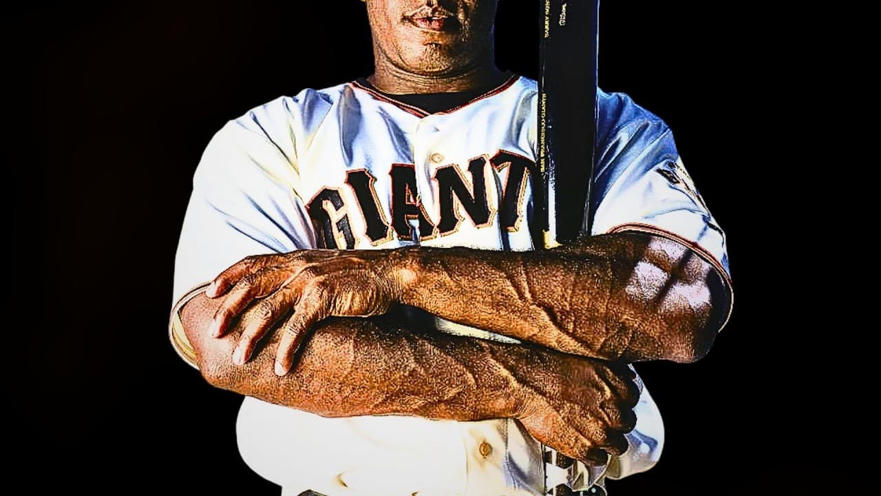 Baseball player in Giants uniform with notably muscular arms crossed, holding bat against black background