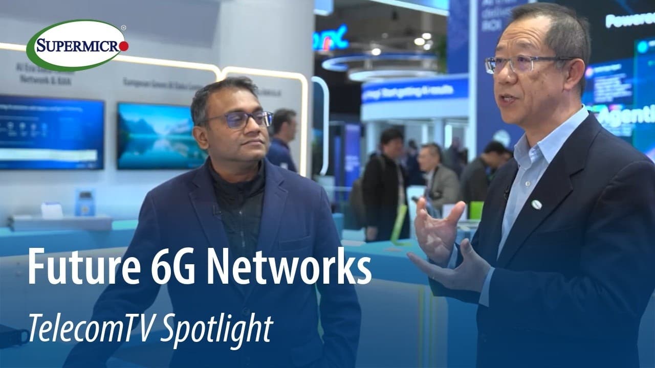 Two professionals discuss telecom technology at a Supermicro booth with blue displays and "Future 6G Networks TelecomTV…